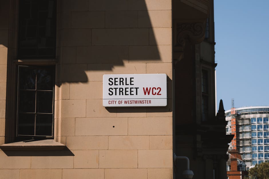 A close-up view of a street sign mounted on a beige stone building in Marylebone, Westminster, indicating 'Serle Street WC2' with a red 'WC2' label and the text 'City of Westminster' beneath. The sign
