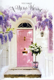 This Marylebone doorway scene feels like a quiet pause between unpacking boxes and welcoming the first guest. The door itself is painted a graceful pale pink, its panels subtly defined, the paint finish soft and matte against the crisp white walls on either side. A single matching shutter, tipped open, introduces a diagonal line that guides the eye upwards to the cascading wisteria. That wisteria forms a fragrant, lavender-toned canopy, with long trails of blossoms hanging like silky tassels. Each cluster shows delicate gradations of colour, from whisper-soft lilac near the base to deeper purple at the tips, the kind of varied hues you might notice while strolling past a flowering courtyard near Portland Place. Beneath this floral curtain, firmly anchored on the stone step, sits a simple grey bucket with a slightly weathered surface. From it, white and cream roses spill in gentle abundance, each flower rounded and lush, some unfurling into open rosettes, others still holding a promise at the centre. Interspersed are soft green leaves, their shapes rounded and calm, providing a quiet backdrop for the roses' velvety petals. Encircling the bucket's base is a narrow pink ribbon tied into a loose bow, its satin catching the light and adding a whisper of polish without competing with the blooms. The lighting feels like late afternoon in Marylebone, warm yet filtered, casting fine shadows along the step and making the pastel tones glow. The whole composition suggests a new home gift left by someone who knows the power of flowers: a simple, heartfelt gesture that says congratulations and welcome, while the roses and wisteria together offer comfort, optimism, and a sense that this pink-framed doorway is the start of something beautiful.